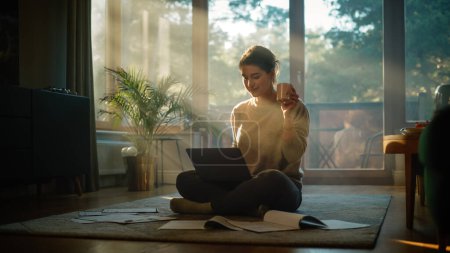Photo for Young Woman Using Laptop at Home Does Remote Work. Beautiful Girl Sitting on the Floor Uses Internet, use Social Media, Write Project. Sunny Stylish Living Room Perfect for Productive Work - Royalty Free Image