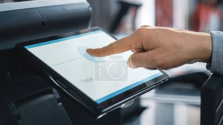 Photo for Close Up Shot of a Person Touching an Electronic Fingerprint Recognition Feature on a Digital Screen in Order to Make a Purchase in a Clothing Store. Customer Buying Items in Shop with Digital ID. - Royalty Free Image