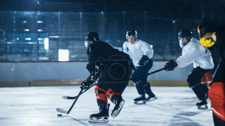 Foto de Ice Hockey Rink Arena: Entrenamiento de Jóvenes Jugadores, Aprendizaje de Palo y Manejo de Puck. Los atletas aprenden a driblar, atacar, defender, proteger, poseer, conducir el pato. - Imagen libre de derechos