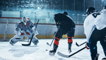 Photo for Ice Hockey Rink Arena: Professional Forward Player Masterfully Dribbles, Breaks Defense, Ready to Hit the Puck with Stick to Score a Goal. Important and Tension Moment. - Royalty Free Image