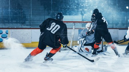 Foto de Arena de pista de hockey sobre hielo: ataques profesionales del jugador delantero, muestra el manejo de palillos experto, driblar, manejar el pato con palo de hockey maravillosamente, defensa incapaz de interceptar. - Imagen libre de derechos