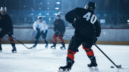 Foto de Ice Hockey Rink Arena: Jugador profesional delantero rompe la defensa, golpeando Puck con palo para marcar un gol. Juego cerca de la puerta o la meta. Momento importante y de tensión en el deporte lleno de emociones. - Imagen libre de derechos