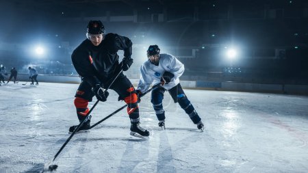 Foto de Ice Hockey Rink Arena: Entrenamiento de Jóvenes Jugadores, Aprendizaje de Palo y Manejo de Puck. Los atletas aprenden a driblar, atacar, defender, proteger, poseer, conducir el pato. - Imagen libre de derechos