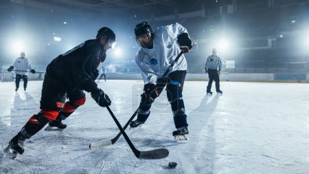 Photo for Ice Hockey Rink Arena: Two Professional Players From Different Teams Fighting for the Puck with Stick. Athletes Play Intense Game Wide of Energy Competition - Royalty Free Image