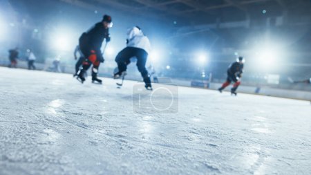 Foto de Ice Hockey Rink Arena: En el fondo borrosa jugadores profesionales de diferentes equipos que luchan por el Puck con palo. Primer plano con enfoque en la nieve. Disparo de ángulo holandés. - Imagen libre de derechos