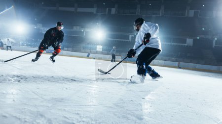 Photo for Ice Hockey Rink Arena: Two Professional Players From Different Teams Fighting for the Puck with Stick During Championship. Athletes Play Intense Game Wide of Energy Competition. Low Dutch Angle Shot. - Royalty Free Image