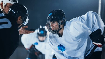 Photo for Ice Hockey Rink Arena Game Start: Two Professional Players Aggressive Face off, Sticks Ready. Referee Holds the Puck. Intense Competitive Game Wide of Brutal Energy. Close-up Portrait Shot. - Royalty Free Image