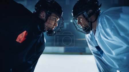 Foto de Ice Hockey Rink Arena Juego Inicio: Dos jugadores profesionales cara agresiva apagado, palos listos. Intenso juego competitivo Amplio de energía brutal, velocidad, poder, profesionalismo. Primer plano Retrato Shot - Imagen libre de derechos