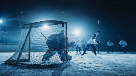 Photo for Ice Hockey Game in Rink Arena: Forward Player who Does Slapshot, Shoots Puck with Stick, Goalie Catches the Puck. Dramatic Moment Forwarder against Goalkeeper. - Royalty Free Image