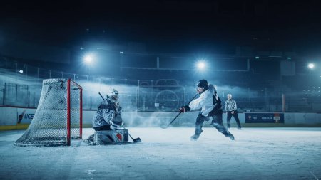 Photo for Ice Hockey Rink Arena: Goalie against Forward Player who Does Slapshot, Shoots Puck with Stick Scores Goal, Goalie Missed it. Forwarder against Goaltender One on One. - Royalty Free Image