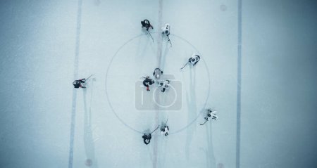 Photo for Top View Ice Hockey Rink Arena Game Start: Two Players Face off, Sticks Ready, Referee Ready to Drop the Puck. Intense Game Wide of Competition. Aerial Shot - Royalty Free Image