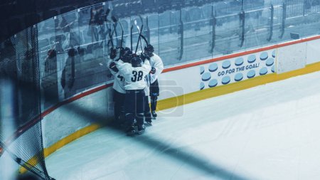 Photo for Ice Hockey Rink: Team Celebrates Victory Near the Board, Players Scream Happily, Cheer, Skate and Raise Hands with Sticks. - Royalty Free Image