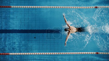 Muskulöse ältere männliche Schwimmer stehen auf einem Startblock und bereiten sich auf den Sprung ins Schwimmbad vor. Gesundes professionelles Athletentraining für die WM. Schuss mit Sonnenbrille