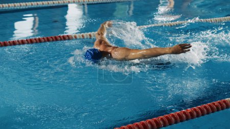 Muscular Mature Male Swimmer Standing on a Starting Block and Prepairing to Jump into Swimming Pool. Healthy Professional Athlete Training for the Championship. Shot with Sunflare