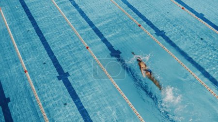 Photo for Muscular Mature Male Swimmer Standing on a Starting Block and Prepairing to Jump into Swimming Pool. Healthy Professional Athlete Training for the Championship. Shot with Sunflare - Royalty Free Image