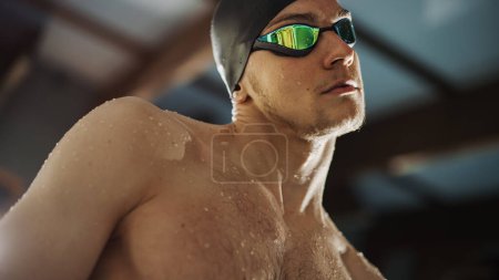 Muscular madura nadador masculino de pie en un bloque de partida y la preparación para saltar a la piscina. Entrenamiento de Atleta Profesional Saludable para el Campeonato. Disparo con Sunflare