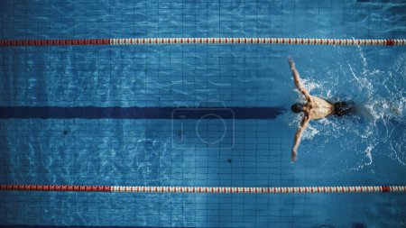 Nageur masculin mature musclé debout sur un bloc de départ et se préparant à sauter dans la piscine. Entraînement professionnel sain d'athlète pour le championnat. Tourné avec Sunflare