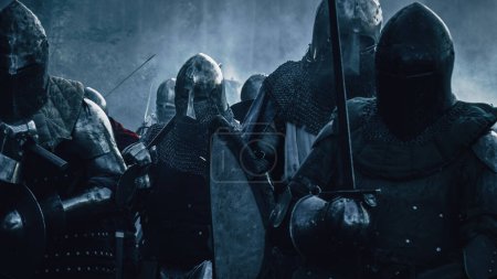 Epic Armies of Medieval Knights on Battlefield Clash, Plate Body Armored Warriors Fighting Swords in Battle (en inglés). Bloody War and Savage Conquest. Representación histórica. Fotografía cinematográfica