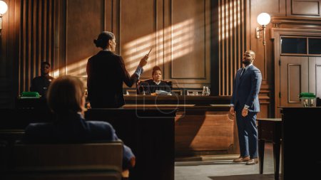 Photo for Court of Law Trial in Session: Charismatic Male Public Defender Making Touching, Passionate Speech to Judge and Jury. Female Prosecutor Objecting to His Arguments and Delivering Her Accusations. - Royalty Free Image