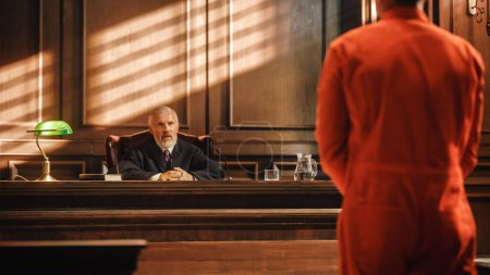 Photo for Court of Law and Justice Trial Proceedings: Law Offender in Orange Jumpsuit is Questioned and Giving Testimony to Judge, Jury. Criminal Denying Charges, Pleading, Inmate Denied Parole. - Royalty Free Image