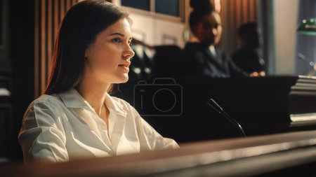 Photo for Court of Law and Justice Trial: Portrait of Beautiful Female Witness Giving Evidence to Prosecutor and Defence Counsel, Judge and Jury Listening. Dramatic Speech of Empowered Victim against Crime. - Royalty Free Image