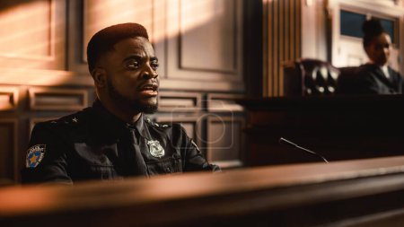 Photo for Court of Law and Justice Trial Stand: Portrait of Black Policeman Witness Giving Testimony to Judge, Jury. African American Officer Providing Evidence. Law Enforcement Agent in Courthouse. - Royalty Free Image