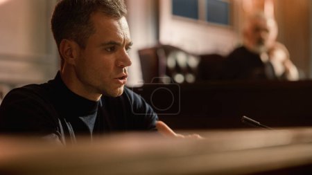 Photo for Court of Law and Justice Concept. Portrait of Handsome Male Witness Giving Testimony to Imparcial Judge, Jury. Confession of the Accused telling His Story, Repenting. Dramatic Heartfelt Moment - Royalty Free Image