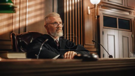 Photo for Court of Law and Justice Trial: Portrait of Impartial Male Judge Listening To the Pleaded Case. Unbiased Decision after Hearing Arguments. Deliberation on Guilty, Not Guilty Verdict - Royalty Free Image