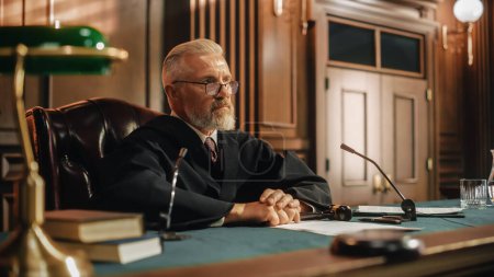 Photo for Court of Law and Justice Trial: Portrait of Impartial Male Judge Listening To the Pleaded Case. Unbiased Decision after Hearing Arguments. Deliberation on Guilty, Not Guilty Verdict - Royalty Free Image