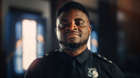 Téléchargez les photos : Authentic Portrait of Happy and Handsome Black Policeman in Universal Uniform Smiling at Camera. "Successful African American Law Enforcement Agent". Gardien de sécurité en salle d'audience au travail. - en image libre de droit