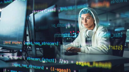 Photo for Late at Night in Office: Portrait of Young Stylish Freelancer Woman Working on Desktop Computer. Non-Binary Person Creating Modern Content. Shot with Visualisation of Running Script Code on Foreground - Royalty Free Image