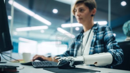 Diverse Body Positive Office: Portrait of Motivated Woman with Disability Using Prosthetic Arm to Work on Computer. Professional with Futuristic Thought Controlled Myoelectric Bionic Hand