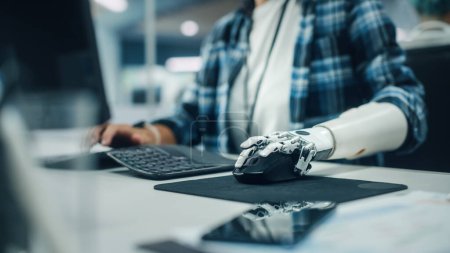 Photo for Inclusive Office: Person with Disability Using Prosthetic Arm to Work on Computer. Professional with Advanced Thought Controlled Body Powered Myoelectric Bionic Limb to Control Mouse. Focus on Hands - Royalty Free Image