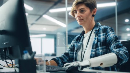 Photo for Diverse Body Positive Office: Portrait of Motivated Woman with Disability Using Prosthetic Arm to Work on Computer. Beautiful Professional with Thought Controlled Body Powered Myoelectric Bionic Hand - Royalty Free Image