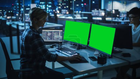 Night Office: Person with Disability Using Prosthetic Arm to Work on Green Screen Chroma Key Computer. Swift and Natural Use of Myoelectric Bionic Hand To Type Code for Software at Night.
