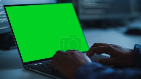 Photo for Close-up Focus on Person's Hands Typing on the Green Screen Chroma key Laptop Computer Keyboard. Software Engineer Create Innovative e-Commerce App. Program Development - Royalty Free Image