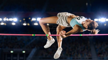 Photo for High Jump Championship: Professional Female Athlete on World Championship Successfully Jumping over Bar. Shot of Competition on Stadium with Sports Achievement Experience. Determination of Champion. - Royalty Free Image