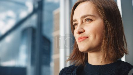 Photo for Portrait of Successful Businesswoman Riding Glass Elevator to Office in Modern Business Center. Young Beautiful Female Looking at Modern Downtown - Royalty Free Image