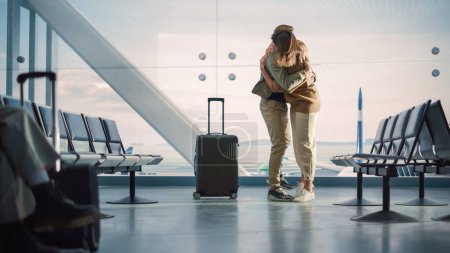 Terminal de l'aéroport Réunion de famille : Un beau couple se réunit au salon d'embarquement. Sourire Girlfiend rencontre l'amour de sa vie après une longue séparation et