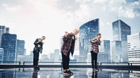 Diverse Gruppe von drei professionellen Tänzern, die eine Hip-Hop-Tanzroutine vor einer großen digitalen LED-Wand mit moderner urbaner Skyline aufführen