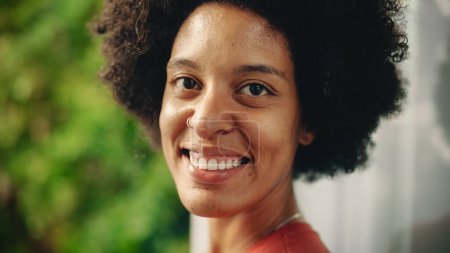 Téléchargez les photos : Fermer Portrait d'une jeune latina heureuse aux yeux bruns, aux cheveux afro et à la pose de piercing du nez pour appareil photo. Belle diversité multiethnique noir hispanique - en image libre de droit