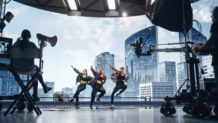 Musik-Clip-Studio-Set: Aufnahme einer Hip-Hop-Videotanzszene mit drei professionellen Tänzern auf der Bühne mit großer LED-Leinwand mit Modern City
