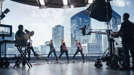 Téléchargez les photos : Clip musical Studio Set : Tournage Hip Hop Vidéo Scène de danse avec trois professionnels Danseurs performant sur scène avec grand écran LED avec ville moderne - en image libre de droit