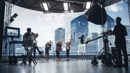 Foto de Conjunto de estudio de clip musical: escena de baile de video de hip hop con tres bailarines profesionales que actúan en el escenario con pantalla led grande con ciudad moderna - Imagen libre de derechos