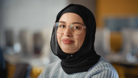Téléchargez les photos : Beau portrait d'une musulmane multiethnique portant du hijab et des lunettes, souriant et posant à la caméra. Happy Diverse jeune femme en - en image libre de droit
