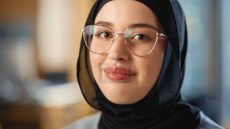 Foto de Hermoso retrato de cerca de una mujer musulmana multiétnica que usa hiyab y gafas, sonriendo y posando encantadoramente en cámara. Feliz joven diverso - Imagen libre de derechos