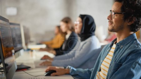 Teacher Giving Lesson to Diverse Multiethnic Group of Female and Male Students in College Room, Learning New Academic Skills on a Computer. Lecturer