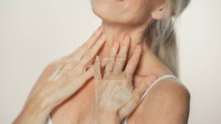 Photo for Anonymous Senior Woman Touching Her Neck, Chest, with Hands, Enjoying Soft Skin. Elderly Female Natural Beauty. Dignity and Grace in Old Age. Isolated - Royalty Free Image