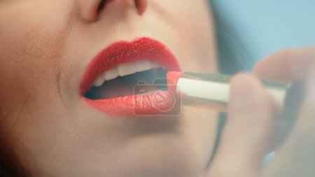 Photo for Beautiful Woman Applies Red Lipstick to Her Sensuous Full Lips. Seductive Female Enjoying Her Beauty. Sexy Hot Mouth shot in Dream Like Style with - Royalty Free Image