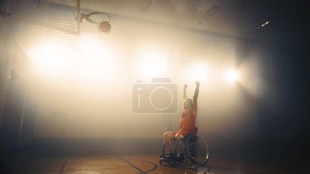 Foto de Juego de baloncesto en silla de ruedas: Jugador que celebra la meta perfecta con manos levantadas después de disparar con éxito. Habilidad de una persona ganadora con discapacidad. Disparo. - Imagen libre de derechos